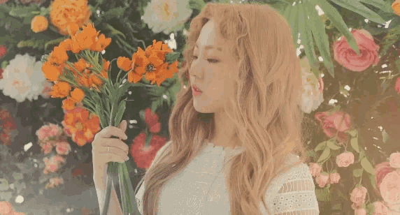 a woman in a white dress holding a vase of flowers
