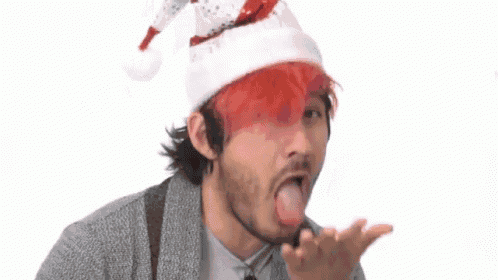 a man wearing a santa hat with red hair is yawning .