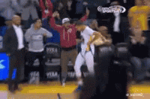 a man in a red hoodie is dancing on a basketball court .