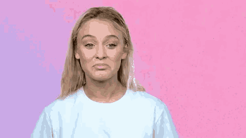 a woman in a white t-shirt is making a funny face .