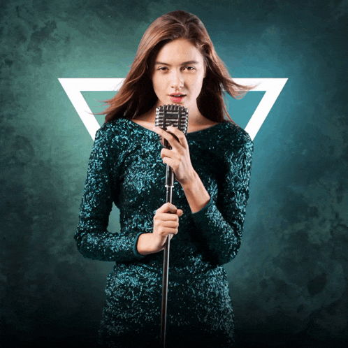 a woman in a green dress holds a microphone