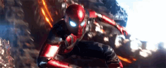 a man in a spiderman suit is flying through the air in a movie scene .