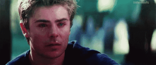 a young man is crying with a tear running down his face .