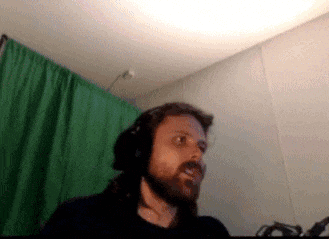 a man with a beard is wearing headphones in front of a green screen