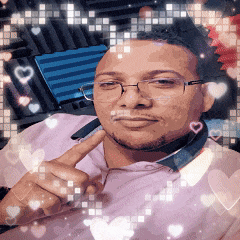 a man wearing glasses and a pink shirt has hearts around him