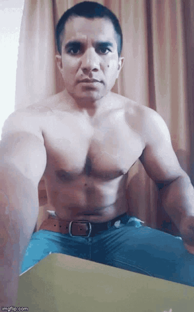 a shirtless man is sitting in front of a window with imgflip.com written on the bottom
