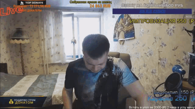 a man is sitting in front of a screen that says " top donate "