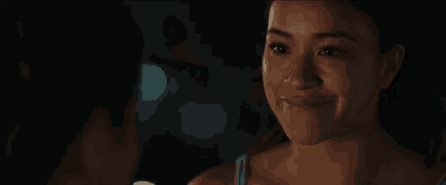 a man is touching a woman 's face in front of a mirror in a dark room .