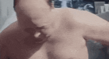 a close up of a man without a shirt making a funny face in a bathroom .