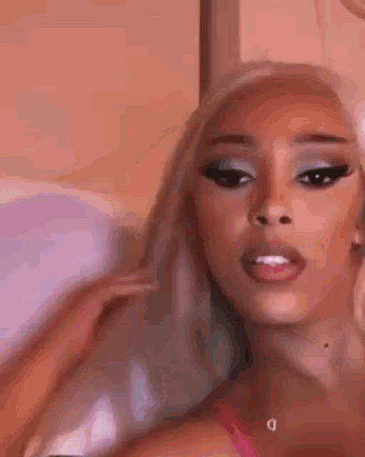 a close up of a woman 's face with a pink bra on .