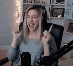 a woman wearing headphones is sitting in front of a microphone in a room .
