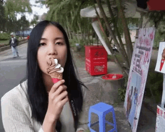a woman eating an ice cream cone with a canon camera strap
