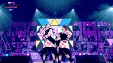 a group of people dancing on a stage with the word live on the bottom