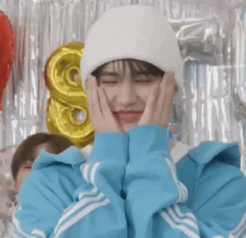a person wearing a blue jacket and a white beanie is making a face .