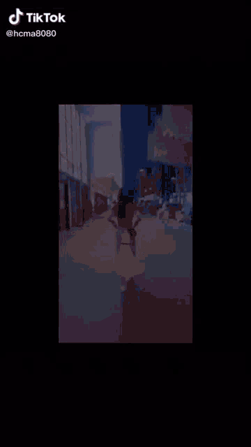 a woman is walking down a street with a yellow bag in her hand ..