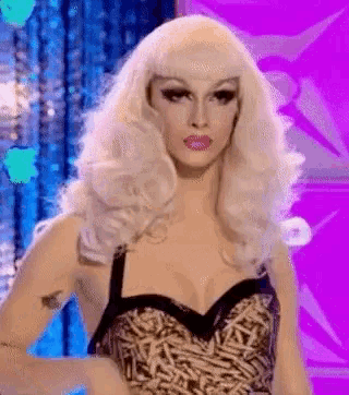 a drag queen wearing a blonde wig and a leopard print bra is standing in front of a purple background .