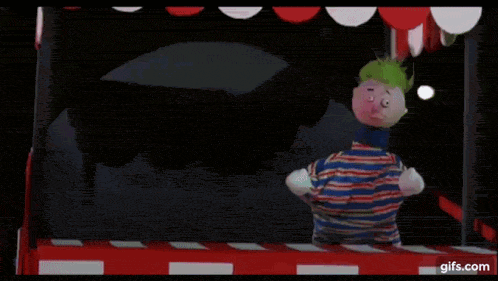 a clown is playing a game with a ghost coming out of it .