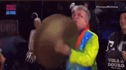a man in a clown costume is holding a globe in his hands