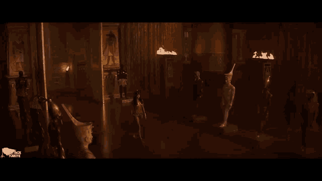 a woman is standing in a room with statues .