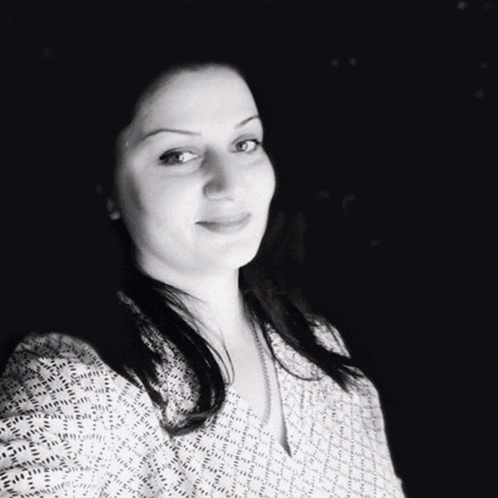 a woman is wearing a floral shirt and looking at the camera