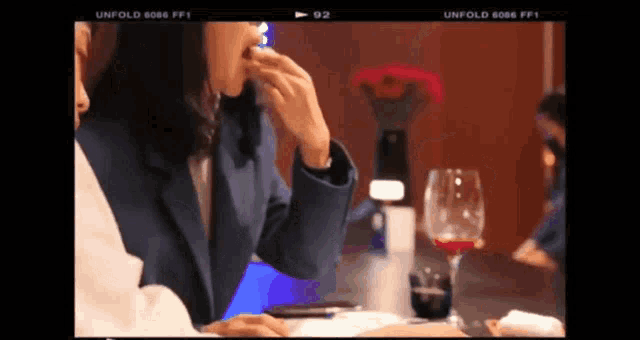 a woman is sitting at a table with a glass of wine in front of her and the words unfold 6066 ff1 on the bottom
