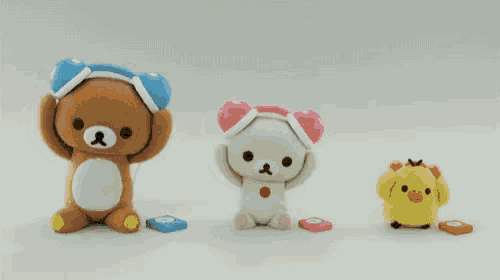 three stuffed animals are sitting next to each other on a white background