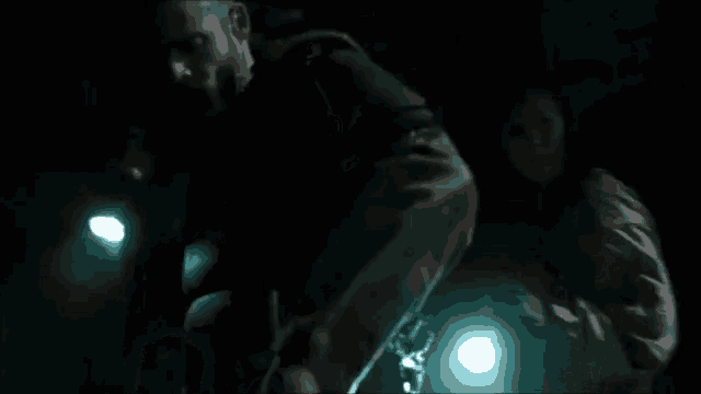 a man in a dark room with a light behind him