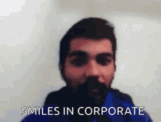 a man with a beard is smiling with the words smiles in corporate behind him .