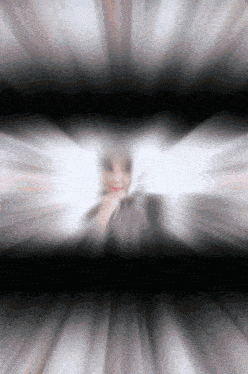 a blurred image of a woman 's face with a black background