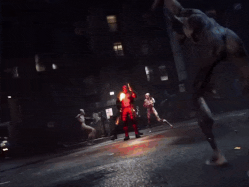 a man in a superhero costume is standing next to another man in a red suit
