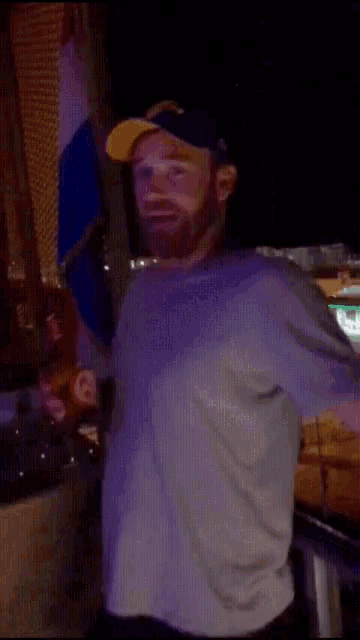 a man in a white shirt is standing in a dark room