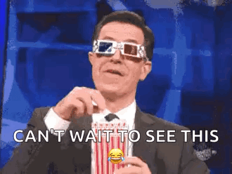 a man wearing a suit and tie is holding a bag of popcorn and wearing 3d glasses .