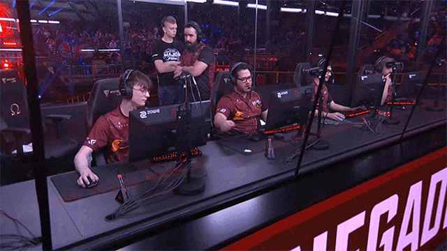 a group of men are sitting in front of computer monitors in a room with a sign that says ecg on it