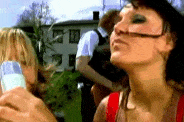 a woman blowing a kiss while holding a glass