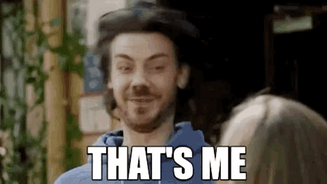 a man is smiling and saying `` that 's me '' in front of a woman .