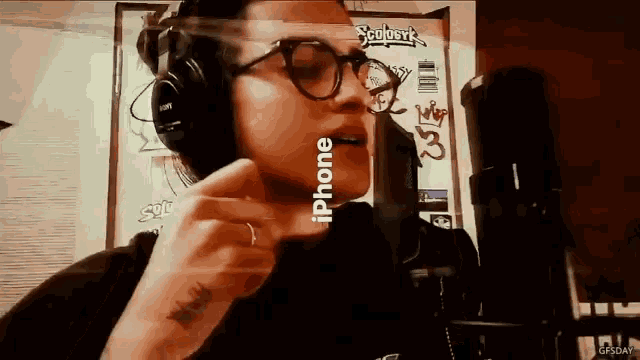a woman wearing headphones is singing into a microphone with the word iphone visible