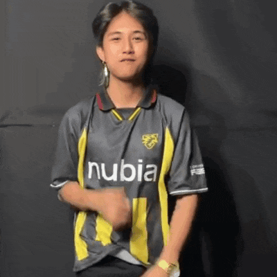 a young man wearing a gray and yellow striped soccer jersey is dancing .