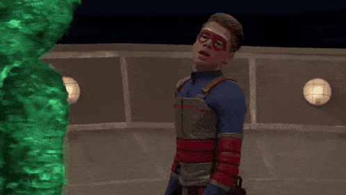 a man in a superhero costume is standing in a circle on a stage