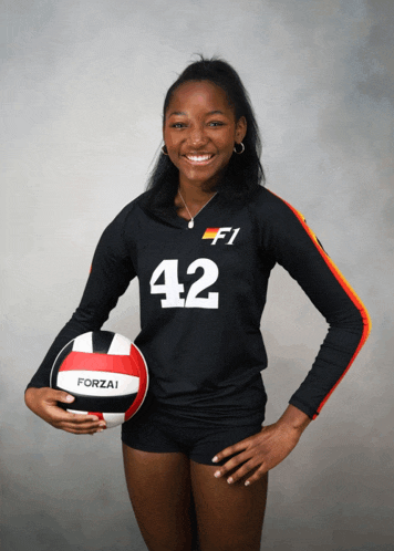 a woman wearing a black jersey with the number 42 on it holds a forzai volleyball