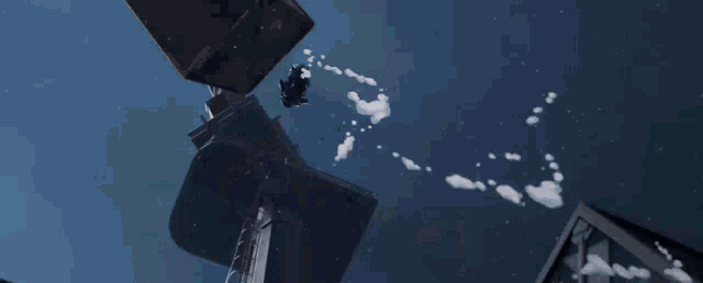 a person is flying through the air in front of a building with snow falling from the sky .