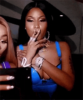 a woman in a blue top is taking a picture of herself with her phone