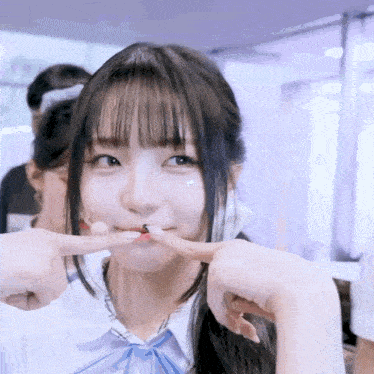 a close up of a girl making a funny face with her finger in her mouth