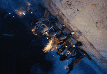 a group of people are standing in a dark alleyway with sparklers in their hands