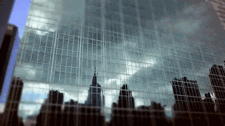 a reflection of a city skyline in the windows of a tall building