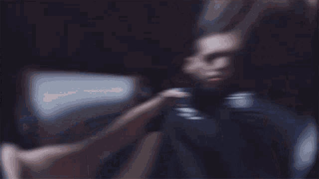 a blurry picture of a man in a suit standing next to a wall