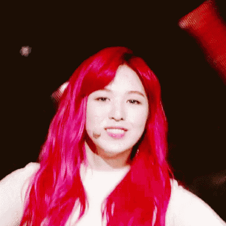 a woman with red hair is wearing a white shirt and a microphone .