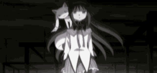 a girl in a white dress is holding a cat on her shoulders .