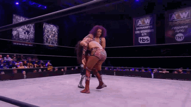 two women are wrestling in a ring with a sign that says aew dynamite