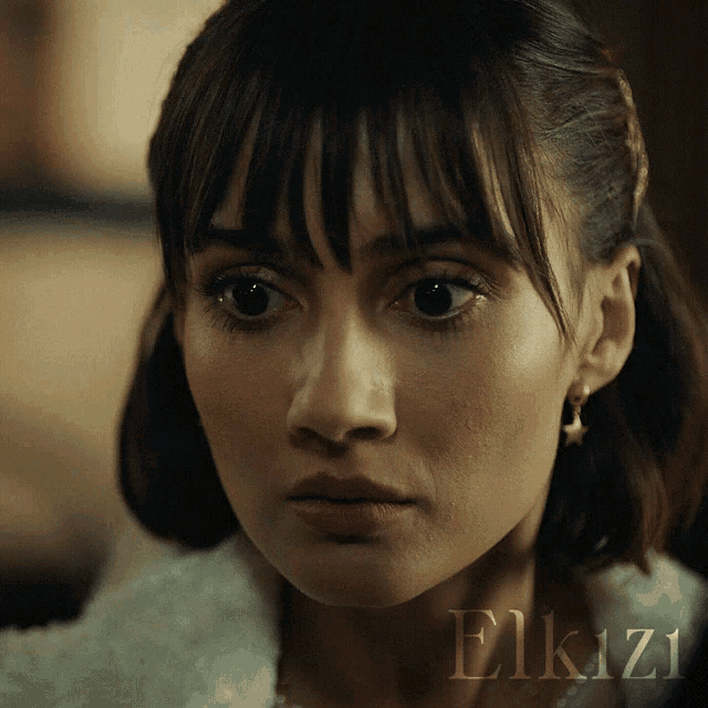 a close up of a woman 's face with the word elkizi written on the bottom