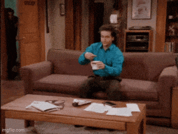 a man is sitting on a couch drinking coffee